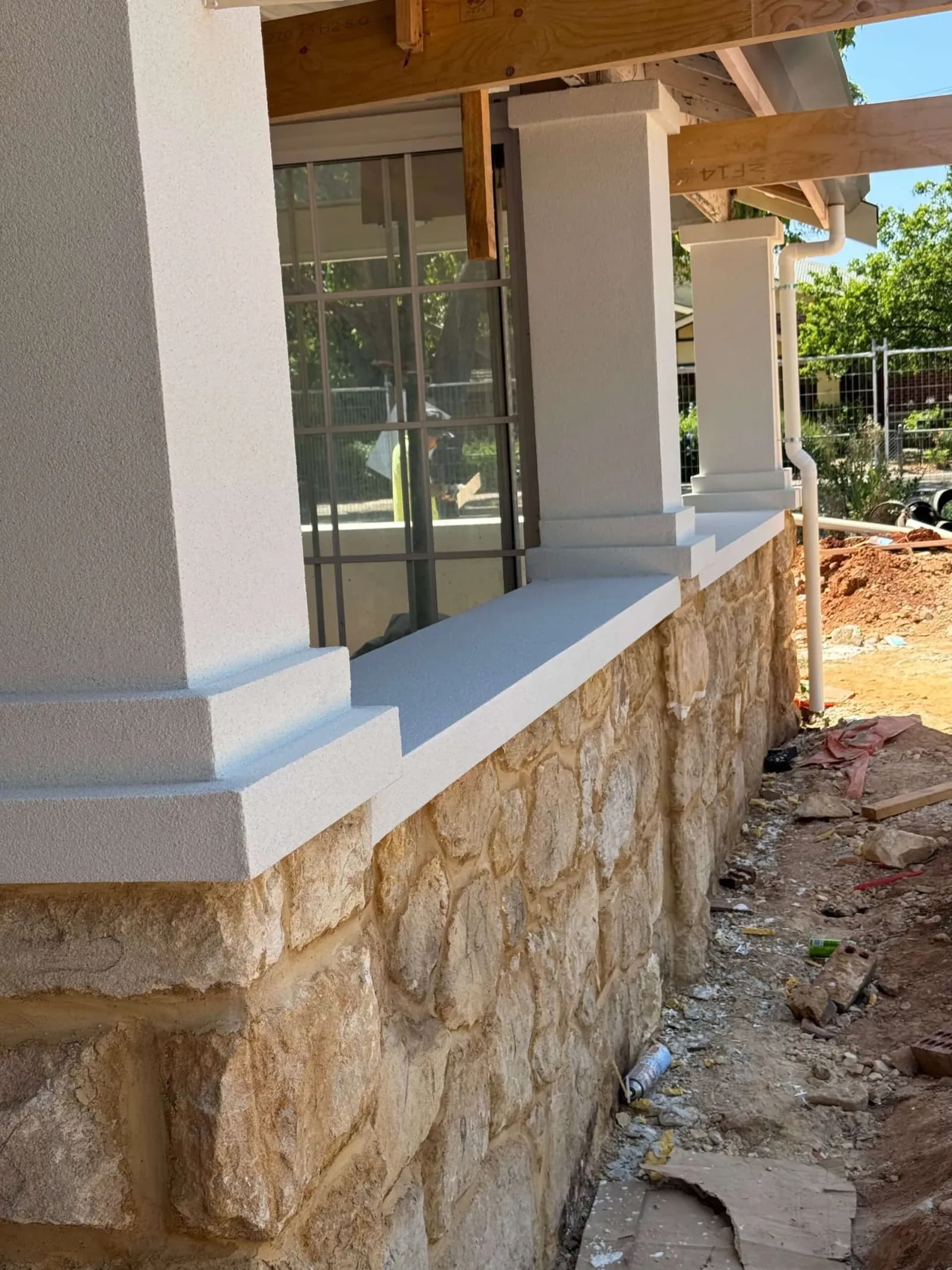 Rendered exterior columns and ledges above a stone base