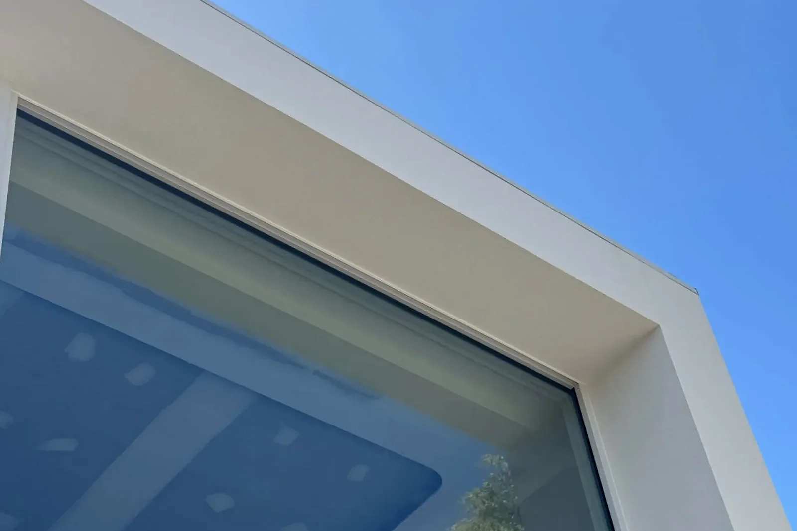 Deep light-rendered reveal around a large dark-framed glazed opening