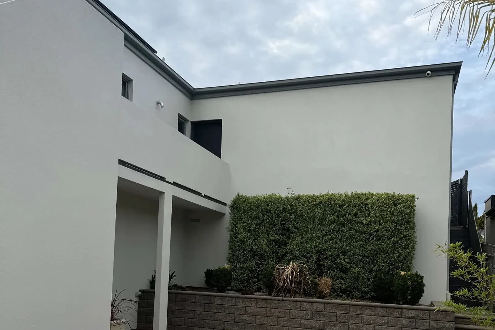 Two-storey residence with a consistent light render finish across the exterior walls